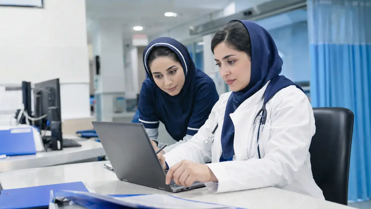 پزشک و پرستار ایرانی در حال بررسی اطلاعات پزشکی با لپ‌تاپ